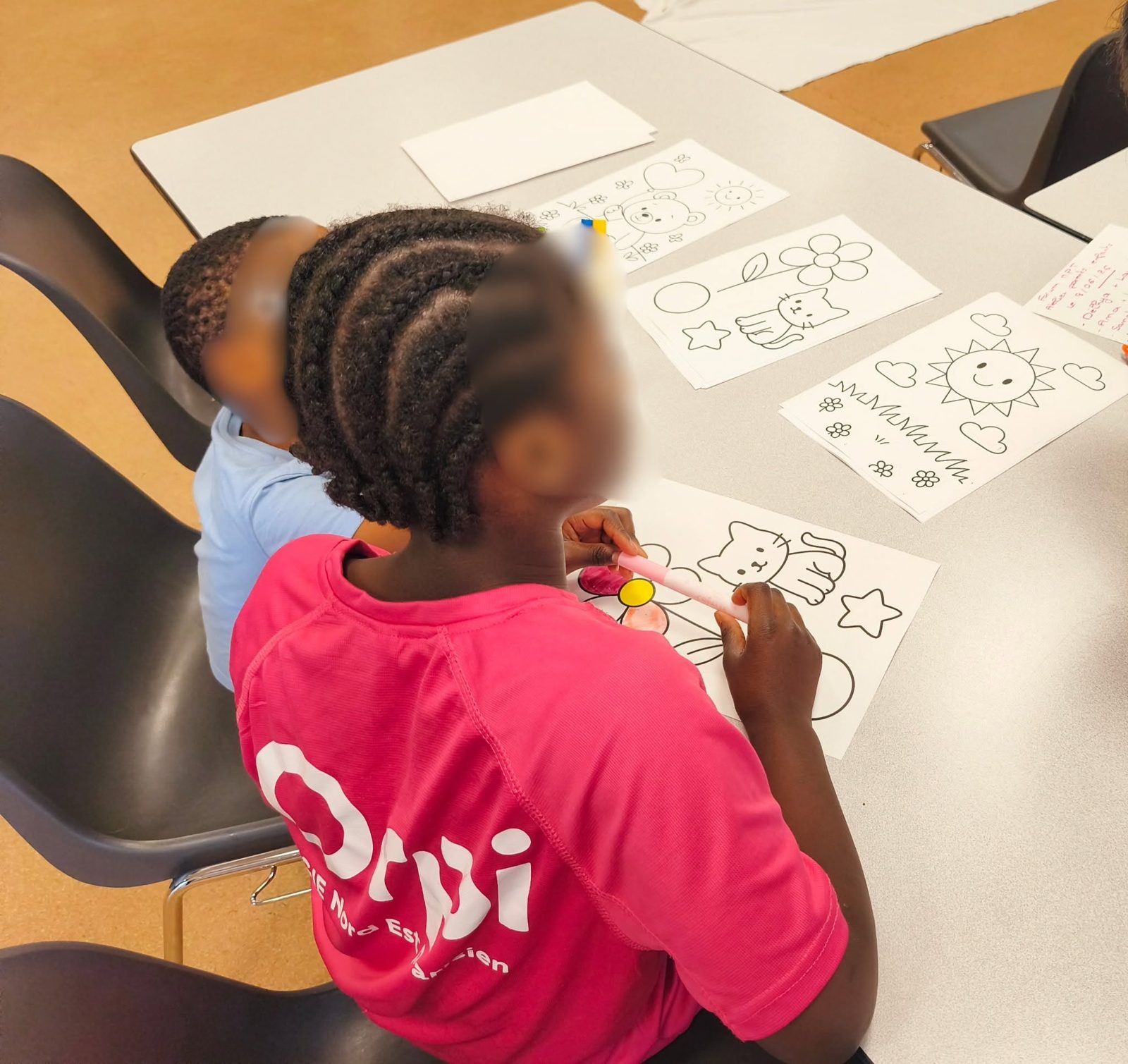 Une enfant colorie des dessins lors d'un atelier