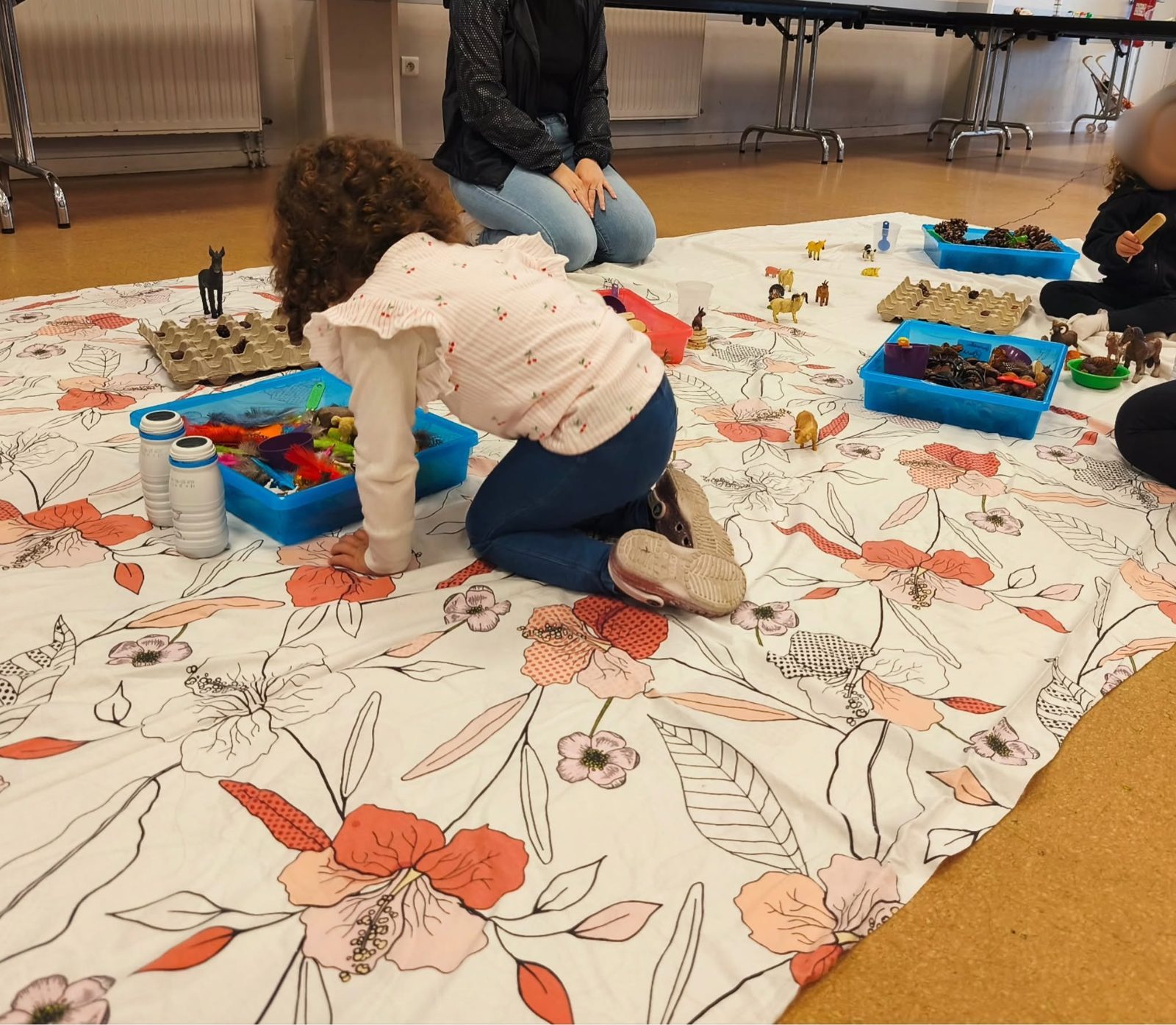 Une enfant joue avec des figurines lors d'un atelier parents-enfants